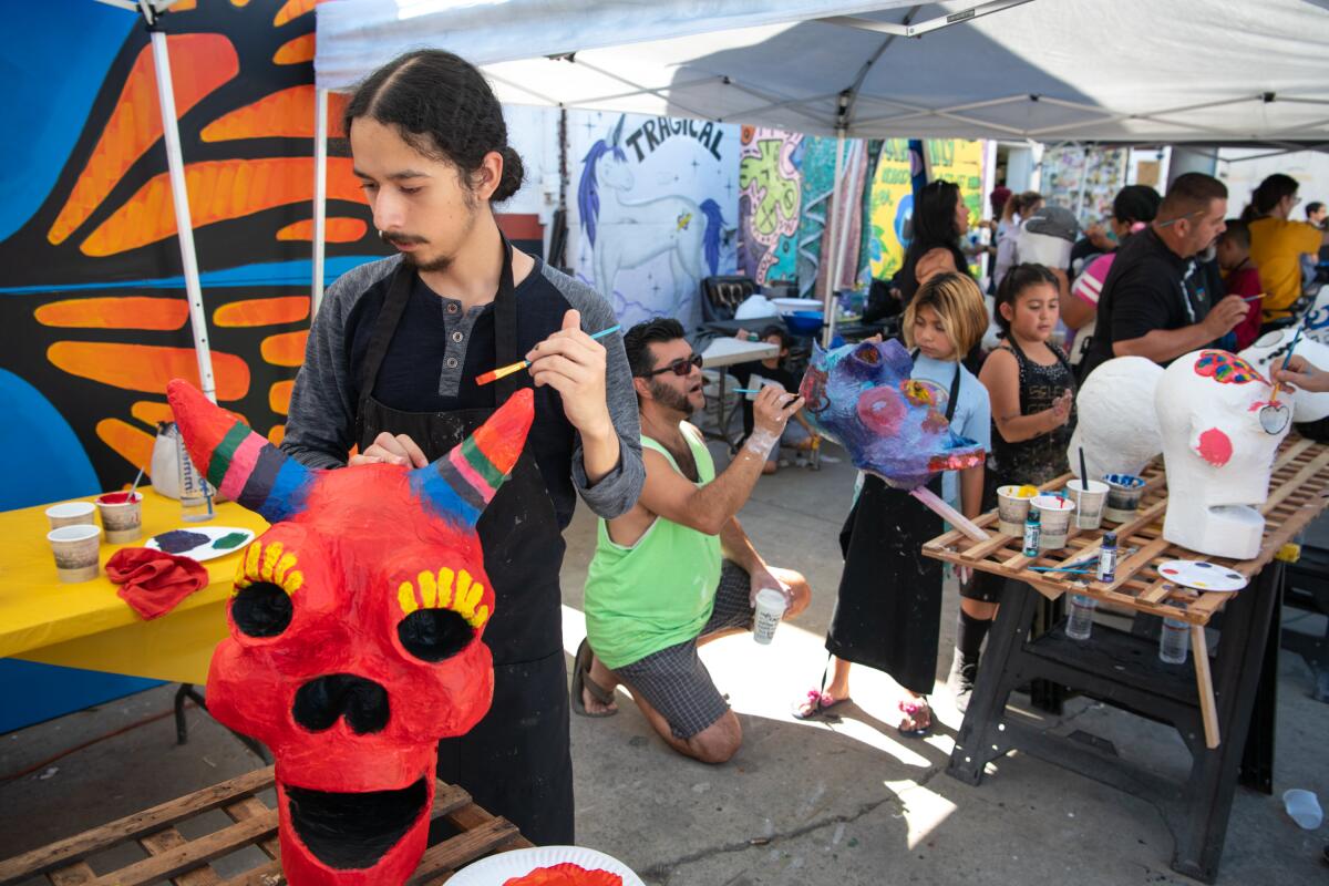 Steve Vazquez, left, paints a paper mache skull for Day of the Dead at the Self Help Graphics Community Arts Workshop.