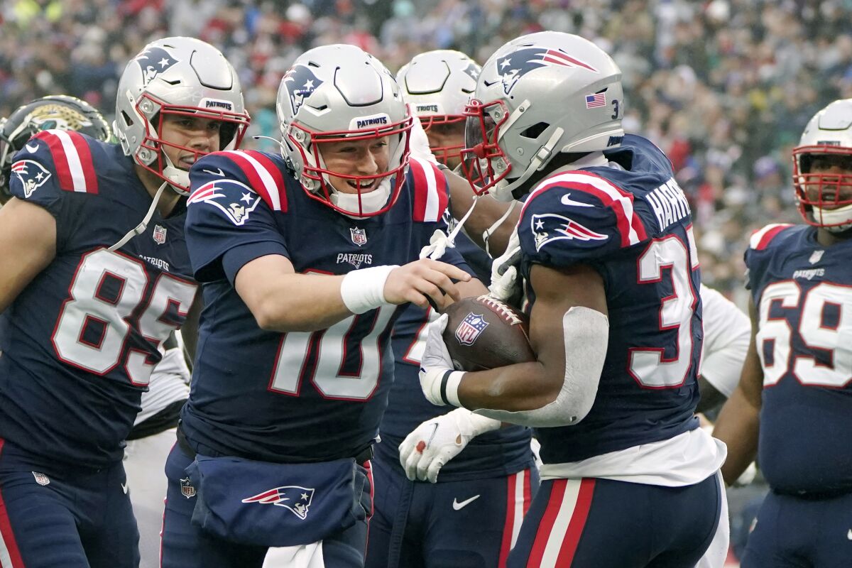 New England Patriots running back Damien Harris celebrates with quarterback Mac Jones.