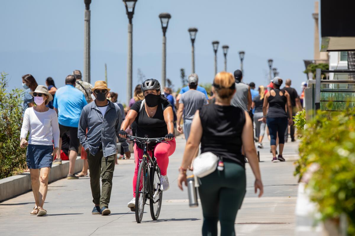 People take advantage of the newly opened walking path on the Strand in Manhattan Beach on Friday.