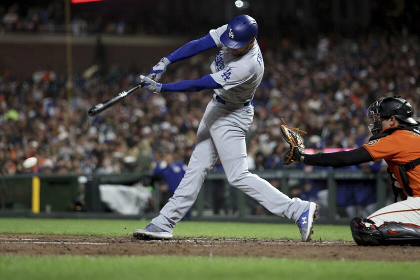 Los Angeles Dodgers' Freddie Freeman hits double in front of San Francisco Giants catcher Blake Sabol during the sixth inning of a baseball game in San Francisco, Friday, Sept. 29, 2023. (AP Photo/Jed Jacobsohn)