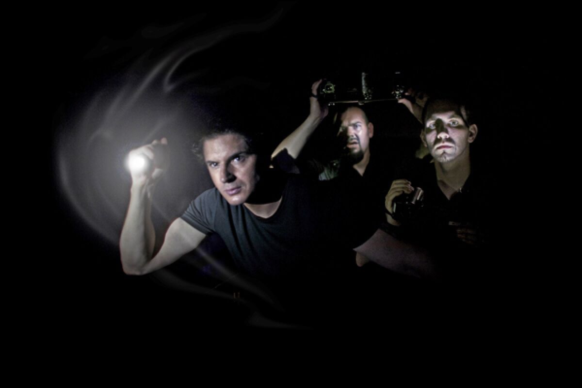 Men searching in the dark with a flashlight on the Travel Channel's "Ghost Adventures" 