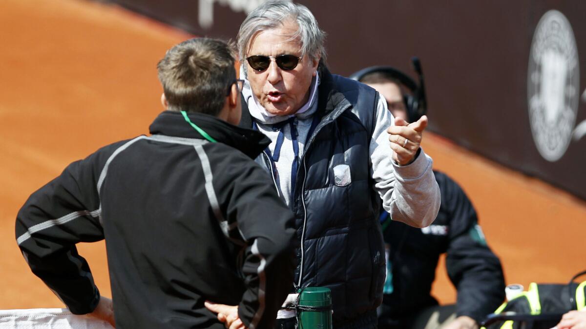 Romania captain Ilie Nastase argues with an ITF official during the Fed Cup match against Britain on Saturday.