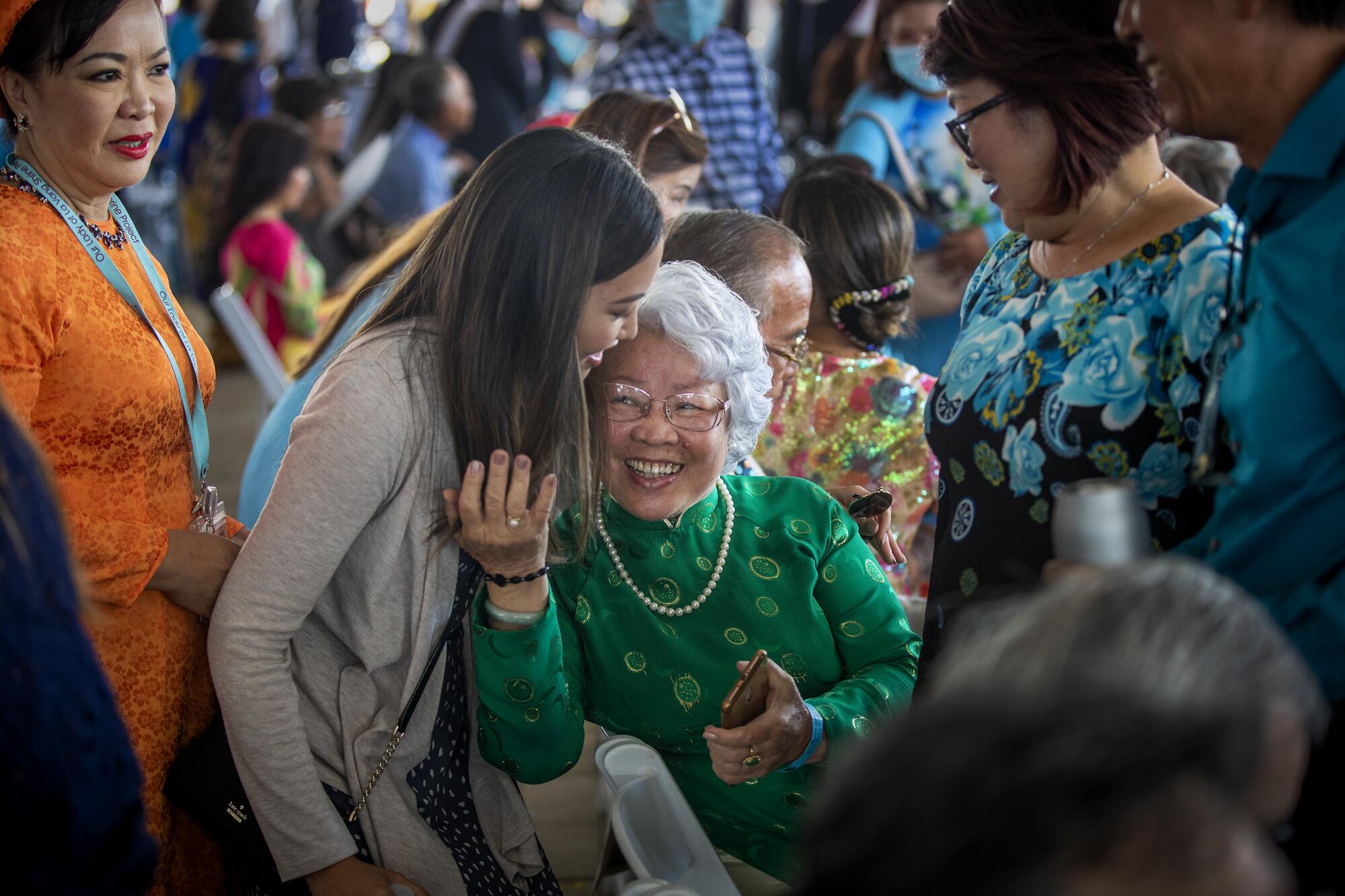 Vietnamese-Americans embrace in celebration of Our Lady of La Vang Solemn Blessing Day.