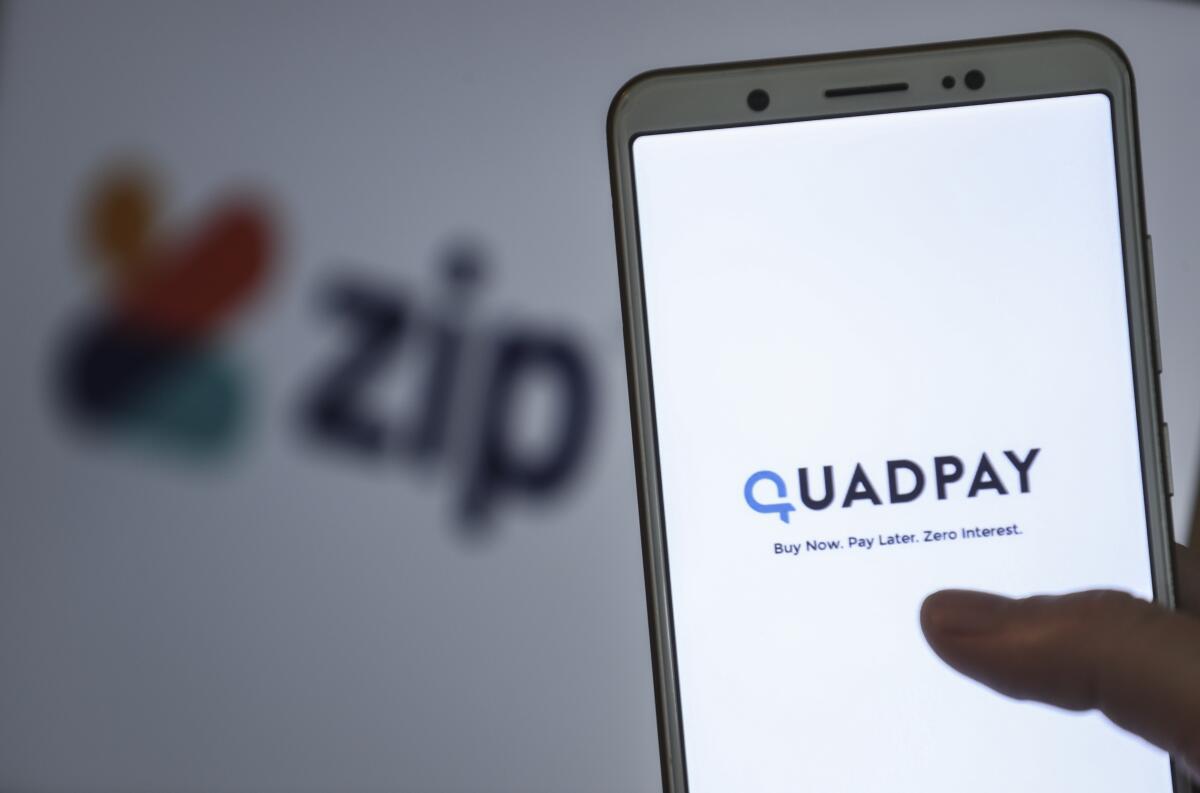 The words Quadpay: Buy Now. Pay Later. Zero Interest. appear on a smartphone screen 