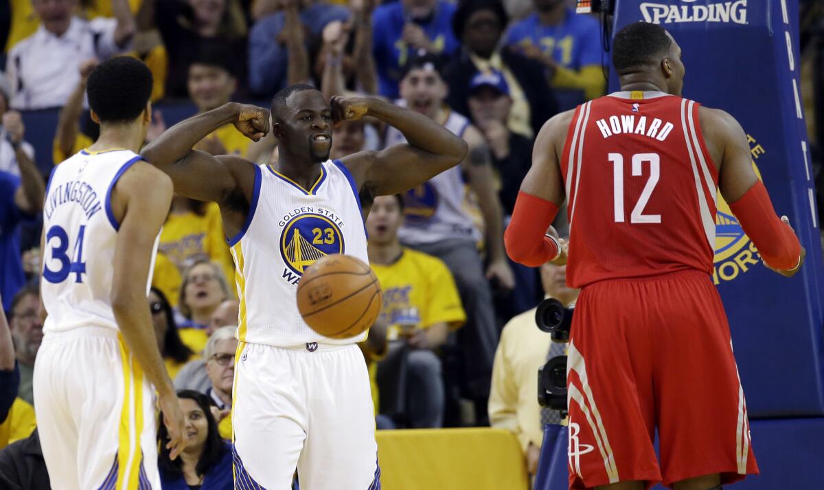Warriors forward Draymond Green (23) flexes in celebration after scoring alongside teammate Shaun Livingston (34) and Rockets center Dwight Howard (12) during the first half of Game 5.