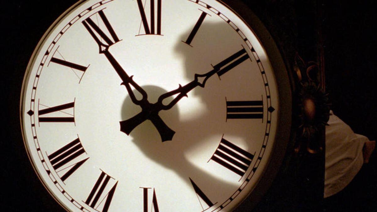 A technician adjusts the minute and second hands from the inside of a Victorian Street Clock.