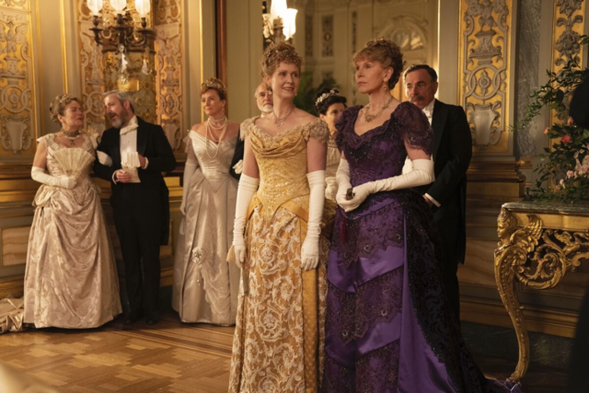 Two women in sumptuous evening gowns in 19th century New York.