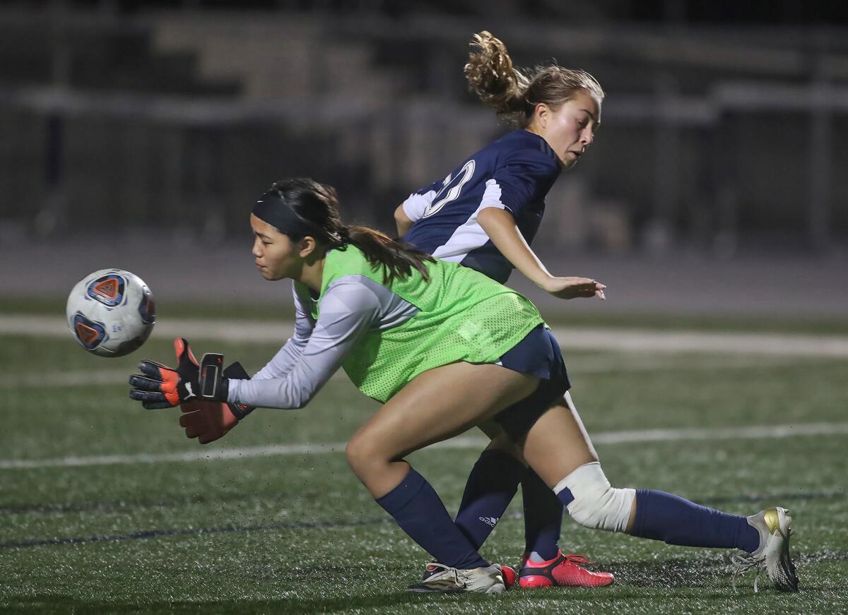 Newport Harbor's Antonella Russo has her shot blocked by Marina goalie Taylee Vo during a Wave League girls' soccer game.