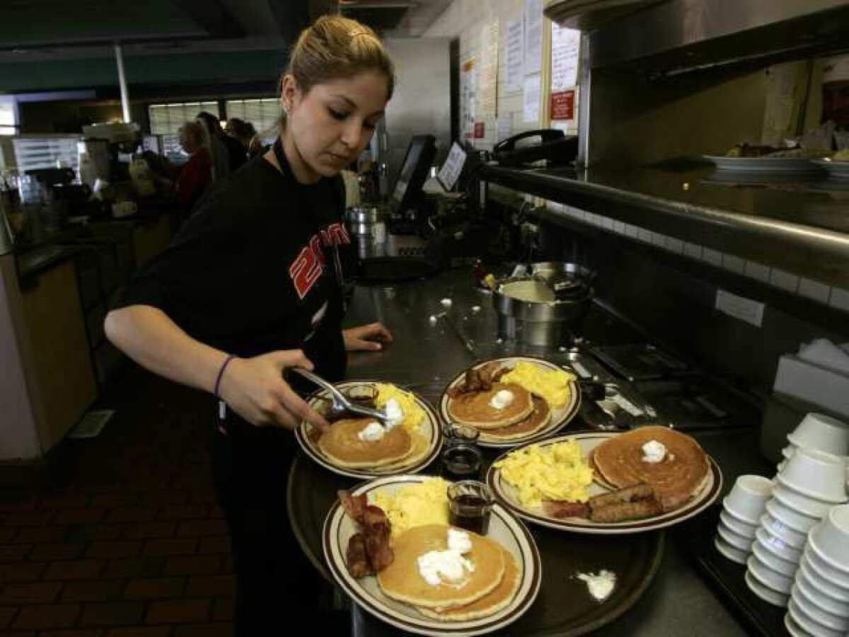 Gaby Estrella prepares breakfast orders at a Denny's in Santa Ana. The chain pledged to try to wean its suppliers off of gestation crates for pigs.