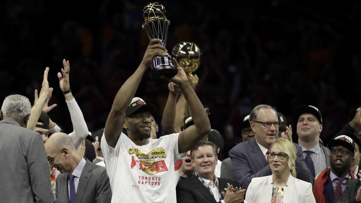 Toronto forward Kawhi Leonard hoists the NBA Finals MVP trophy after the Raptors' 114-110 victory over the Golden State Warriors on Thursday night in Oakland.