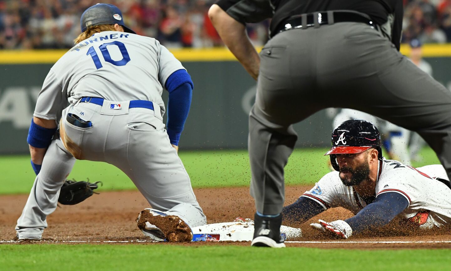 Braves Nick Markakis beats the tag of Dodgers Justin Turner on an error by Cody Bellinger.