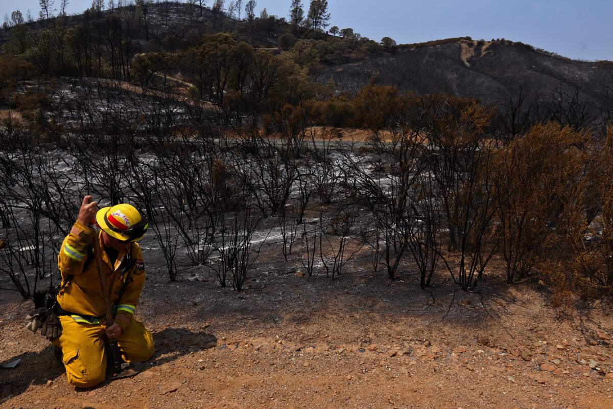 Engineer David Irvine rests next to a fire-ravaged hillside along Water Trough Road in Lake County south of Clearlake on Aug. 5, 2015.