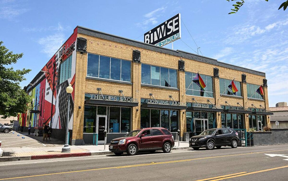 An exterior of a yellow-brick two-story building with "Bitwise South Stadium" sign topping its flat roof.
