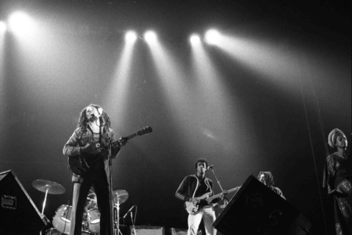 Bob Marley performing on stage in a black-and-white photo