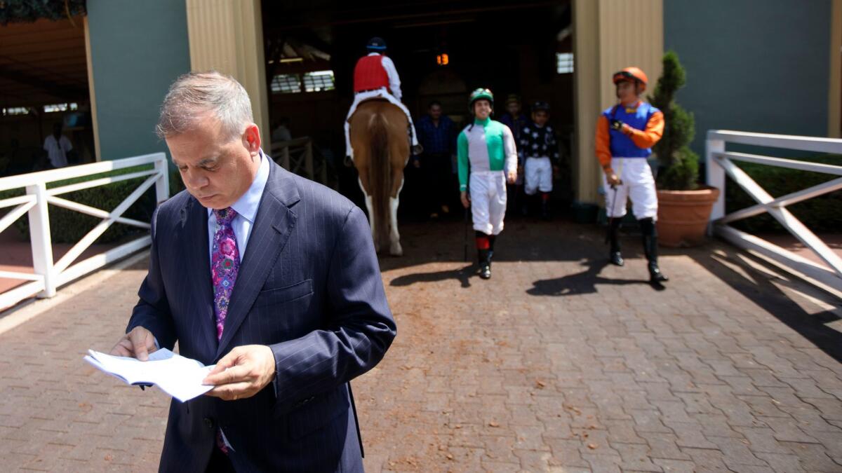 Racetrack executive Tim Ritvo reviews some papers outside the paddock at Santa Anita Park on June 3.