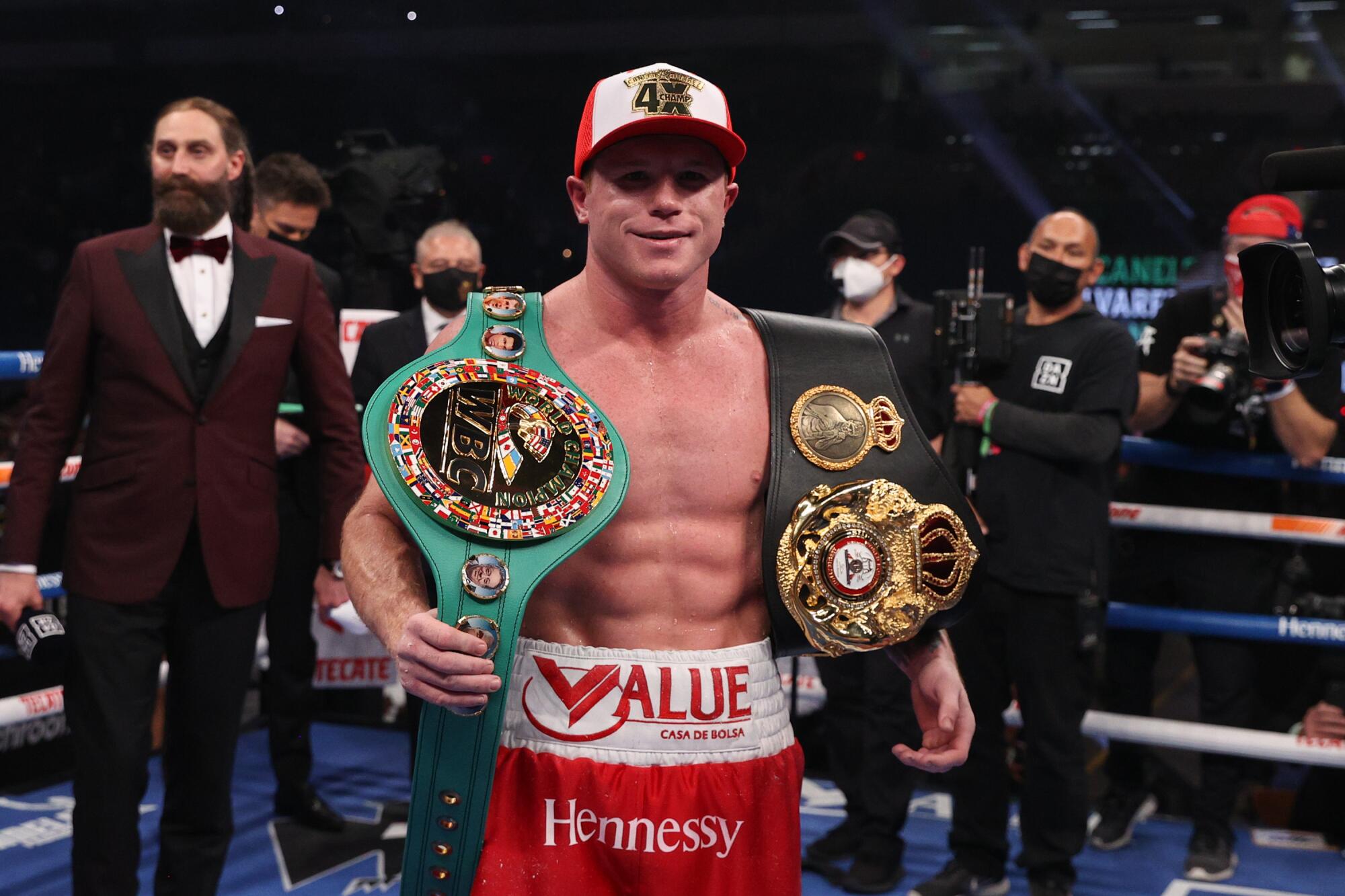 Saul "Canelo" Alvarez holds up championship belts after beating Callum Smith 