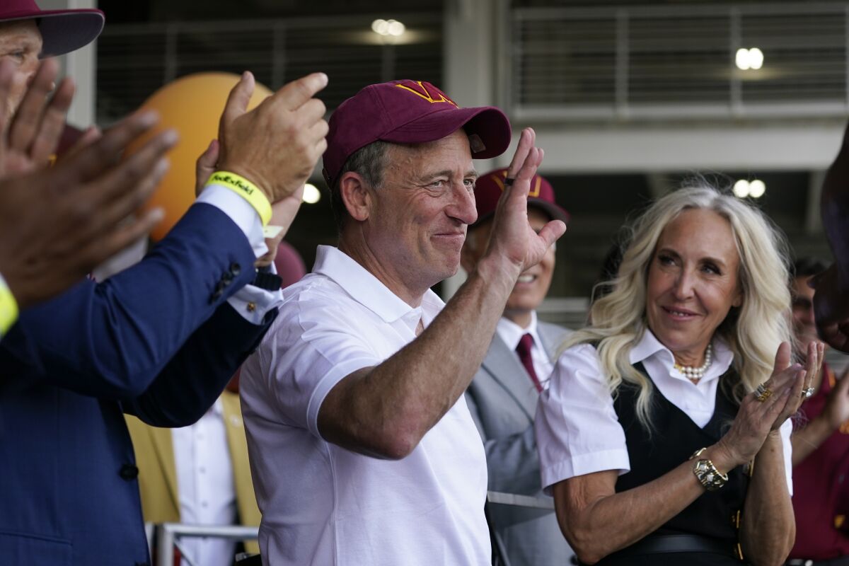 Josh Harris waves to Washington Commanders fans during a pep rally at FedEx Field.