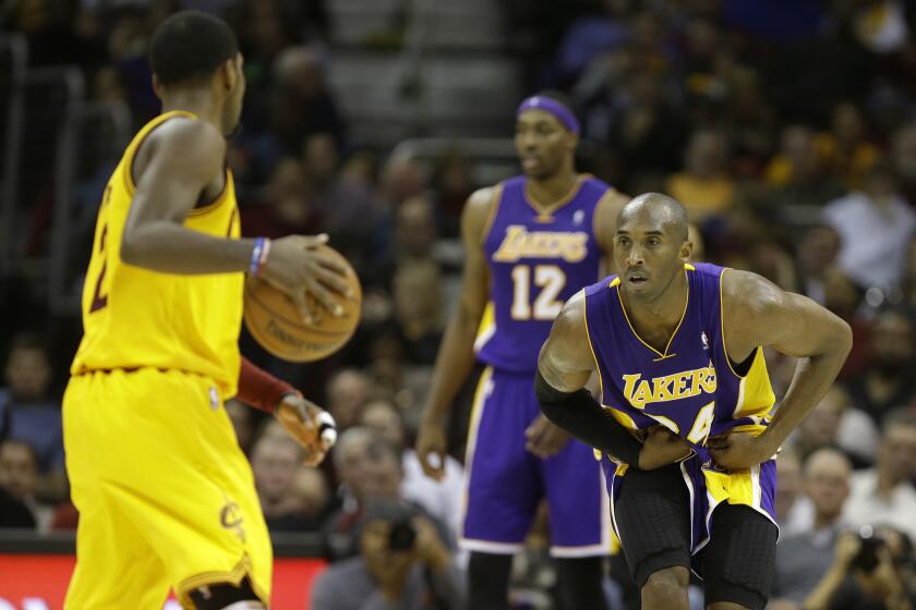 Lakers' Kobe Bryant defends against Cleveland Cavaliers' Kyrie Irving on Dec. 11, 2012.