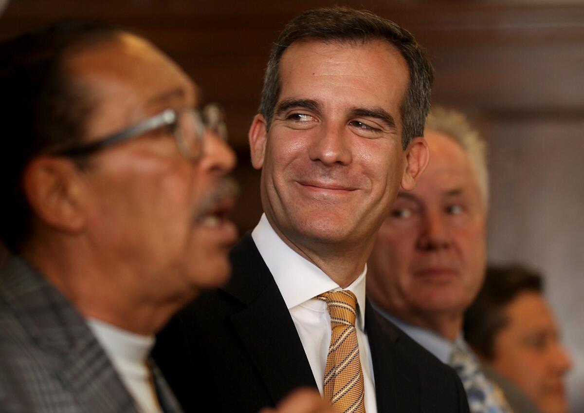 Los Angeles Mayor Eric Garcetti breaks into a smile during a news conference at City Hall last month. He'll be taking questions from the public at a curbside desk Friday in Boyle Heights.