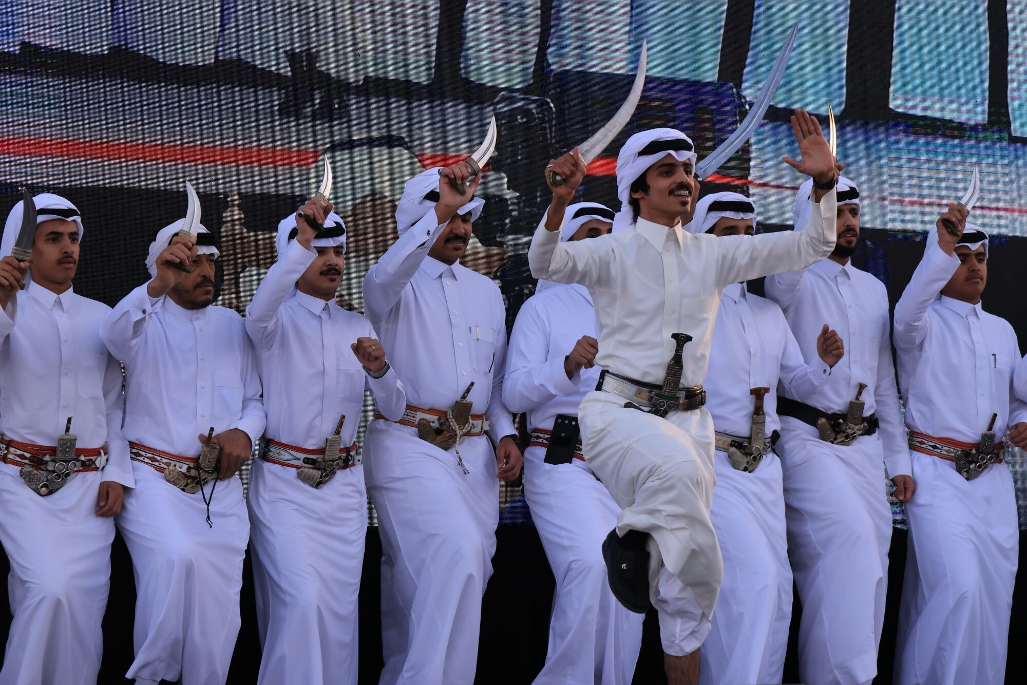 Kavisli bıçakları tutan adamlar geleneksel bir Suudi dansı yapıyor.