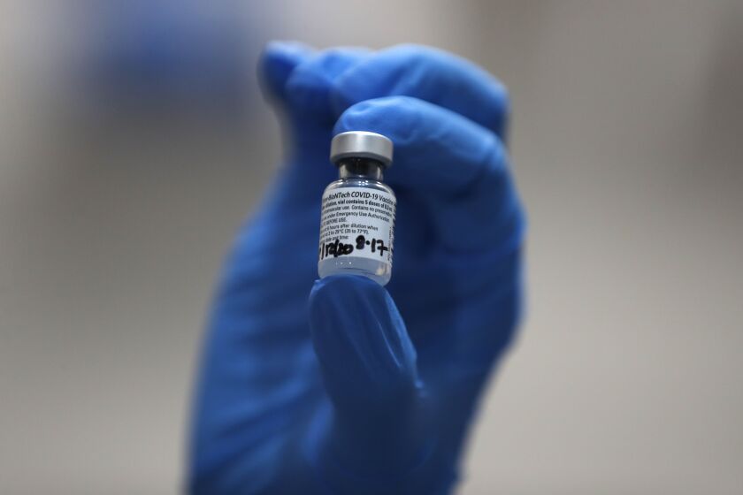 A nurse holds a phial of the Pfizer-BioNTech COVID-19 vaccine at Guy's Hospital in London, Tuesday, Dec. 8, 2020. U.K. health authorities rolled out the first doses of a widely tested and independently reviewed COVID-19 vaccine Tuesday, starting a global immunization program that is expected to gain momentum as more serums win approval. (AP Photo/Frank Augstein, Pool)