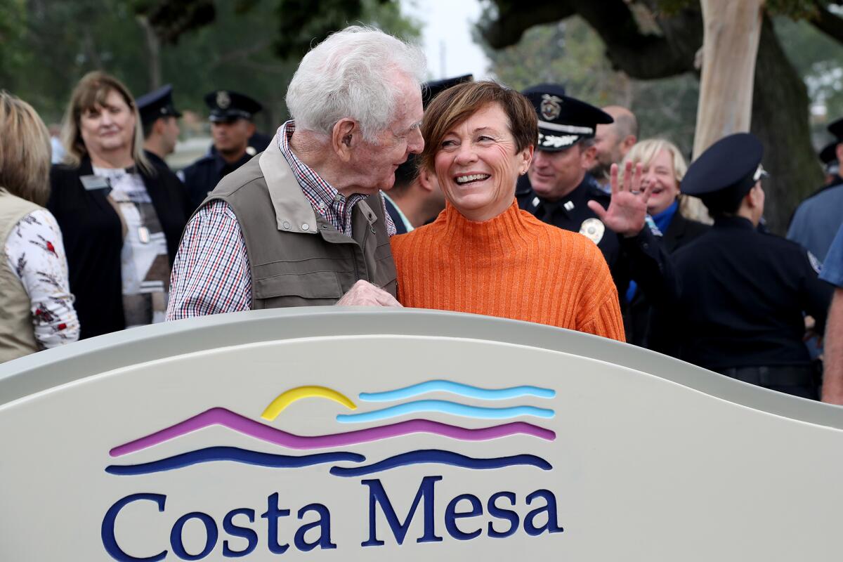 Former Costa Mesa police chief Roger Neth, left, and Cathy Jo Liebel share a laugh during a dedication ceremony Thursday.