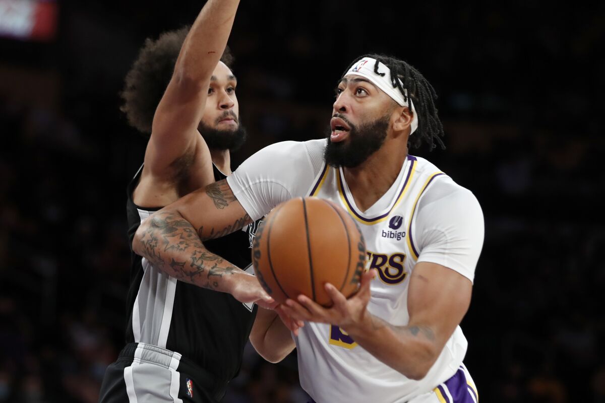 Lakers forward Anthony Davis, right, goes up against San Antonio Spurs guard Derrick White during Sunday's game.