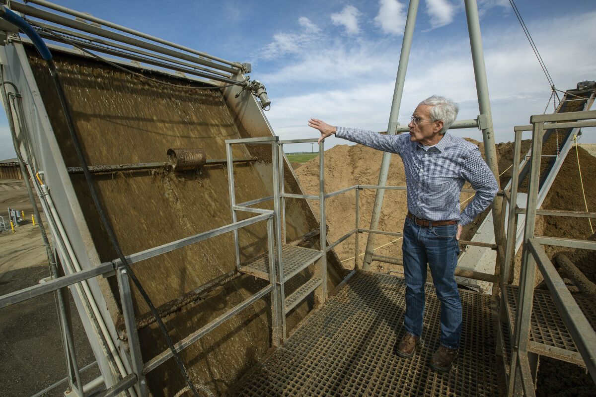 Lyle Schlyer, president of Calgren Renewable Fuels, stands atop a manure separator that separates cow dung into liquid and solid parts.