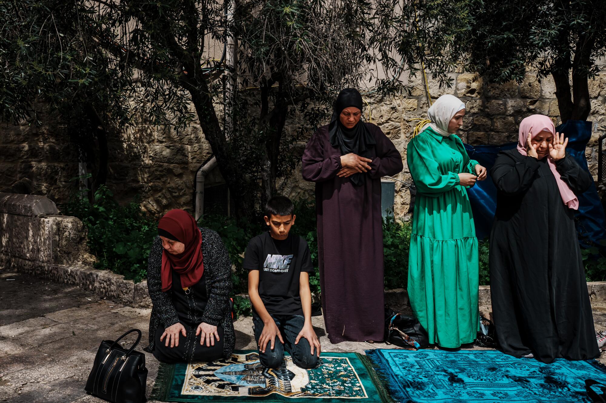 An overflow of worshipers make the Dhuhr afternoon prayers outside the entrance to Al Aqsa Mosque.