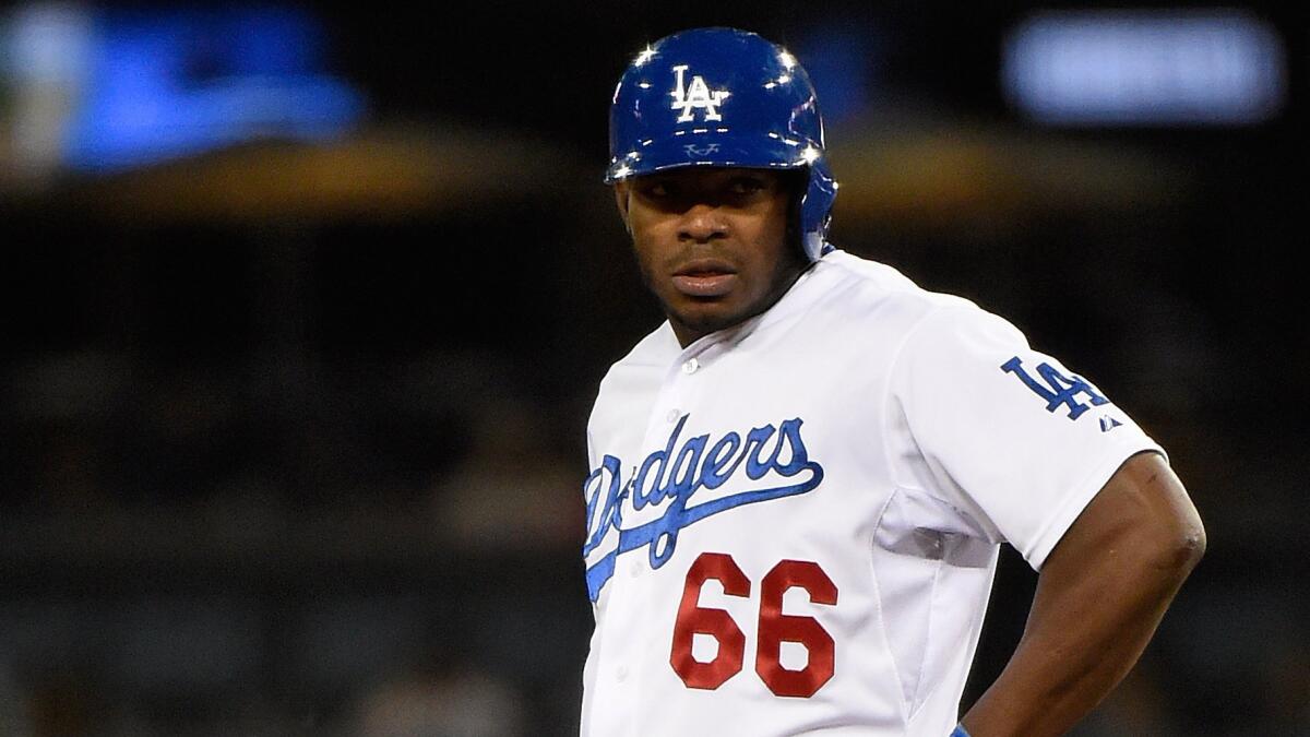 Dodgers right fielder Yasiel Puig stands on second base after hitting a run-scoring double against the Colorado Rockies on April 18. On Friday, he left a rehab game early after feeling tightness in his injured hamstring.