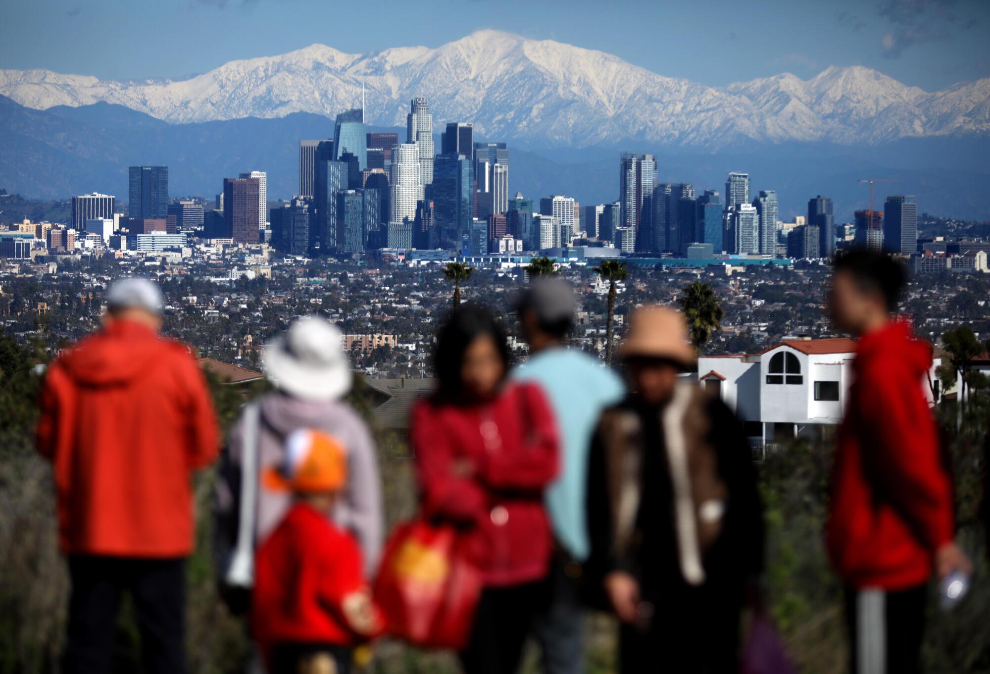 Many came to view the Los Angeles skyline against a backdrop of snow capped San Gabriel mountains.