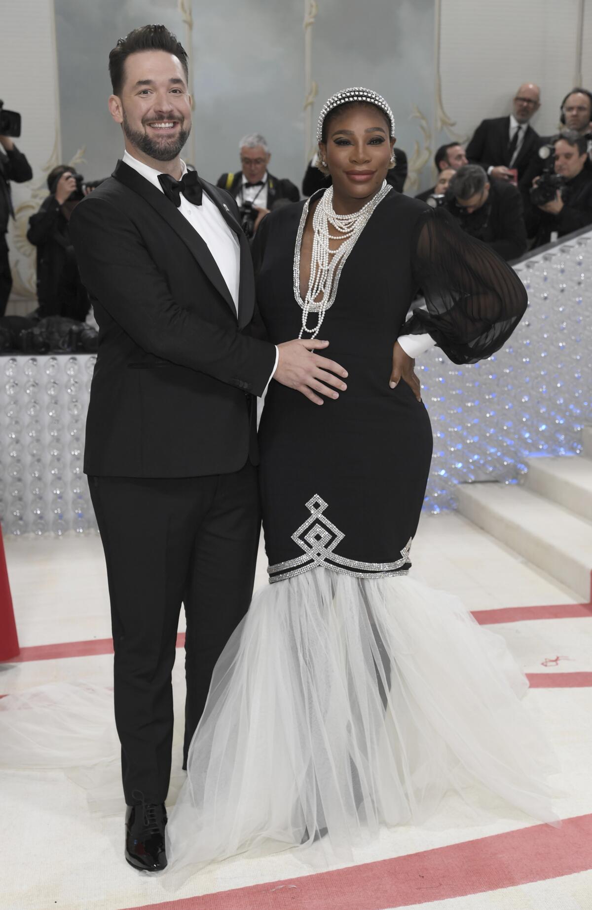 Alexis Ohanian, left, touches his wife Serena Williams' pregnant belly as they pose in formalwear