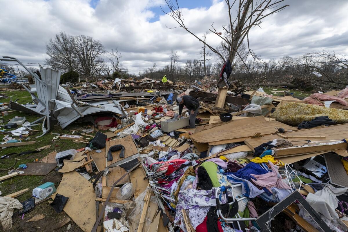 ARCHIVO - Gente entre los restos de un tornado nocturno en Sullivan, Indiana,