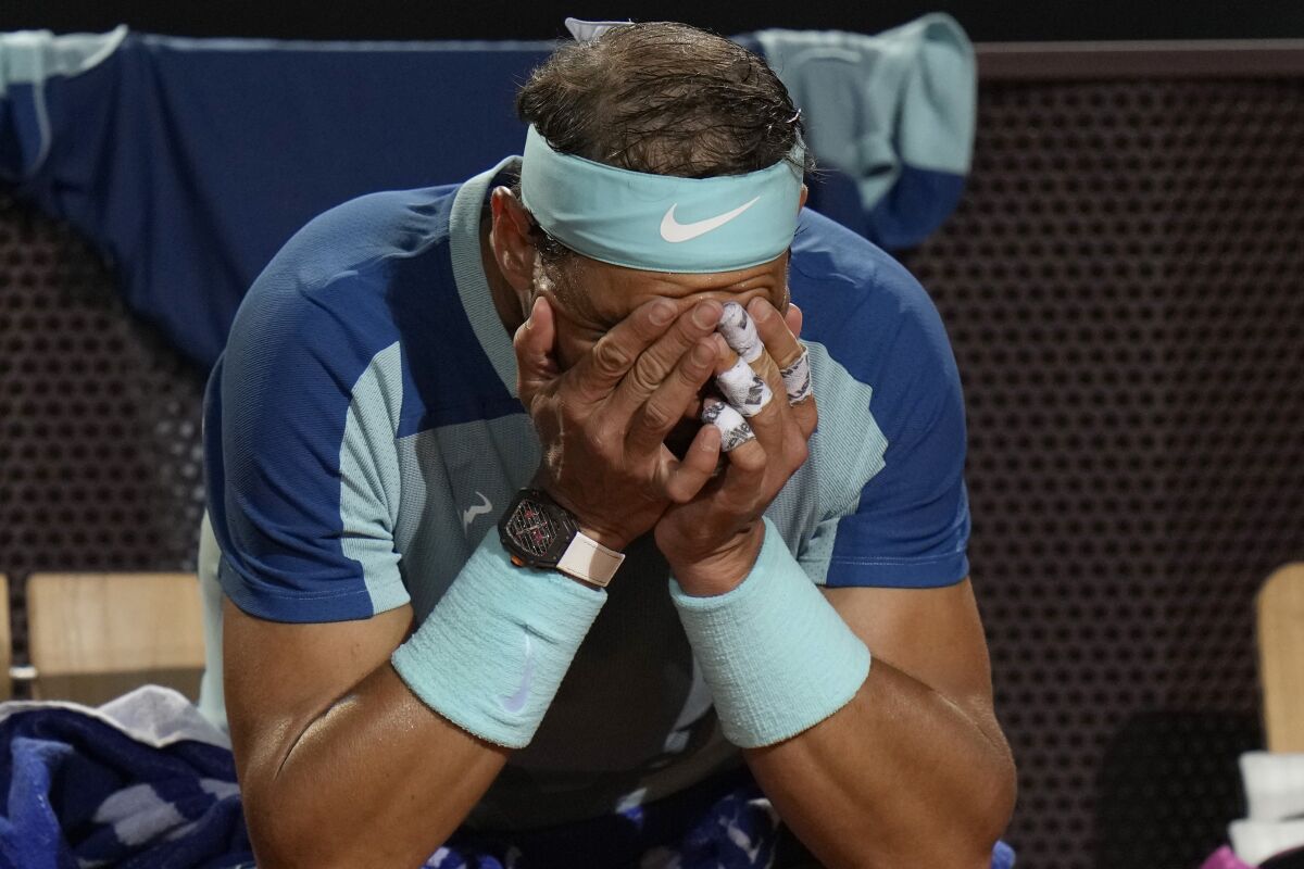 Rafael Nadal of Spain touches his face during his match against Denis Shapovalov of Canada at the Italian Open tennis tournament, in Rome, Thursday, May 12, 2022. Shapovalov beat Nadal 1-6, 7-5, 6-2. (AP Photo/Alessandra Tarantino)