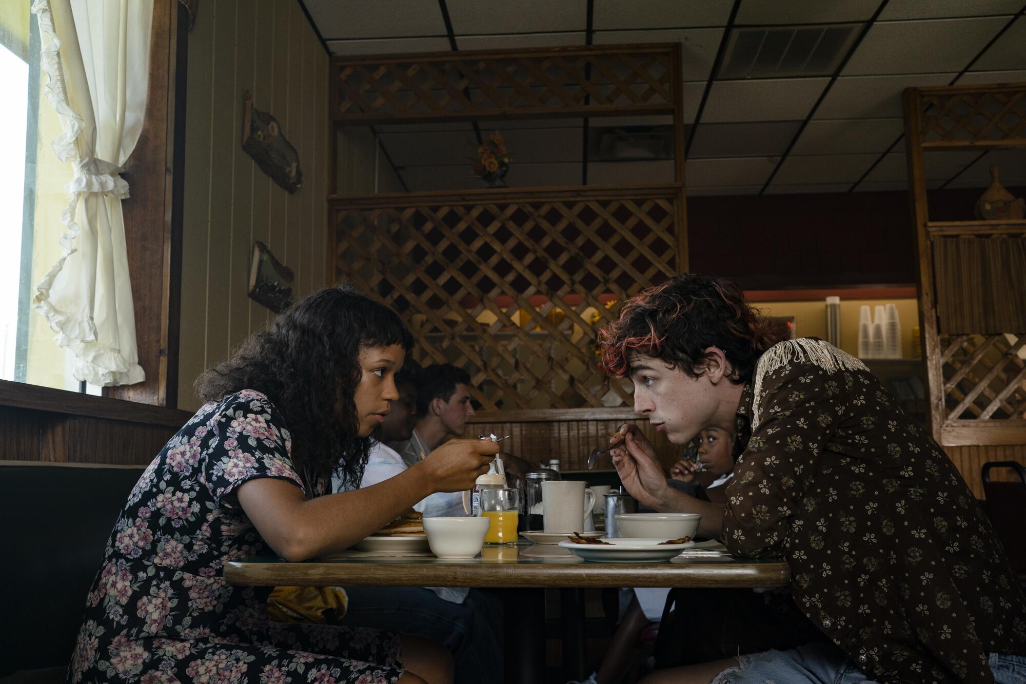 Two teenagers eating breakfast at a diner