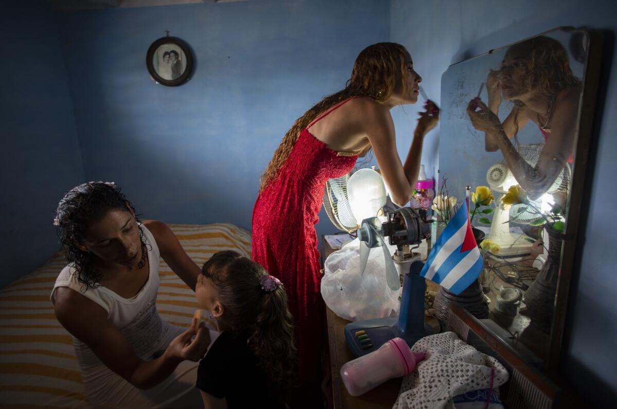 Liusba Grajales, a la izquierda, maquilla a su hija Ainhoa mientras su pareja Lisset Díaz Vallejo se prepara 