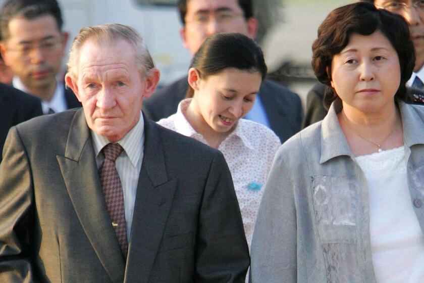 FILE - In this July 18, 2004 file photo, former U.S. Army deserter to North Korea, Charles Jenkins, left, escorted by his wife Hitomi Soga, right, and their daughter Mika, center, arrives at Tokyo's Haneda International Airport. Jenkins, who married Soga, a Japanese abductee and lived in Japan after their release in the 2000s, has died. He was 77.(AP Photo/Itsuo Inouye, File)