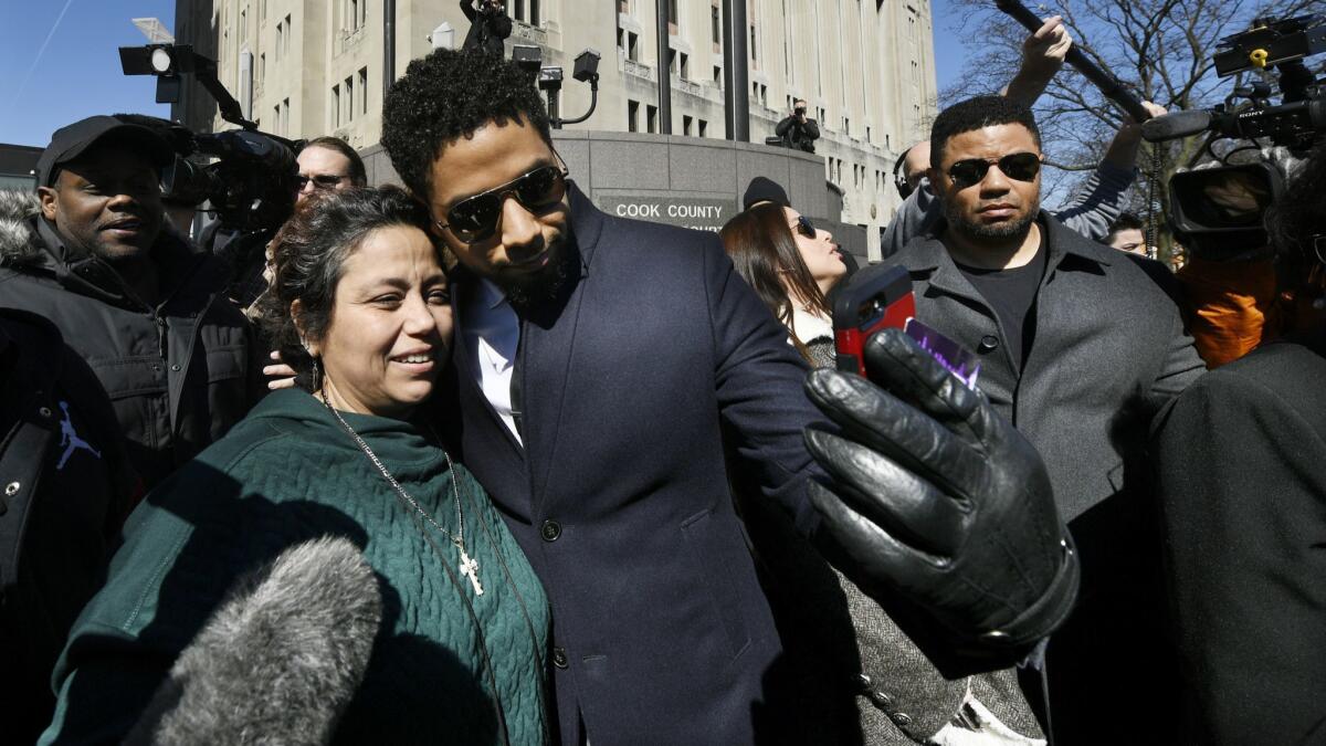 Jussie Smollett takes a selfie with a fan while leaving Cook County Court.