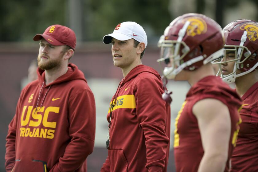 In this Tuesday, March 5, 2019 photo, provided by University of Southern California Athletics, new USC offensive coordinator Graham Harrell, center, watches during NCAA college football practice in Los Angeles. Harrell stepped into one of the highest-profile assistant jobs in college football after Kliff Kingsbury left USC without calling a play. The Trojans' new offensive coordinator is working hard to get up to speed in spring practice. (John McGillen/USC Athletics via AP)