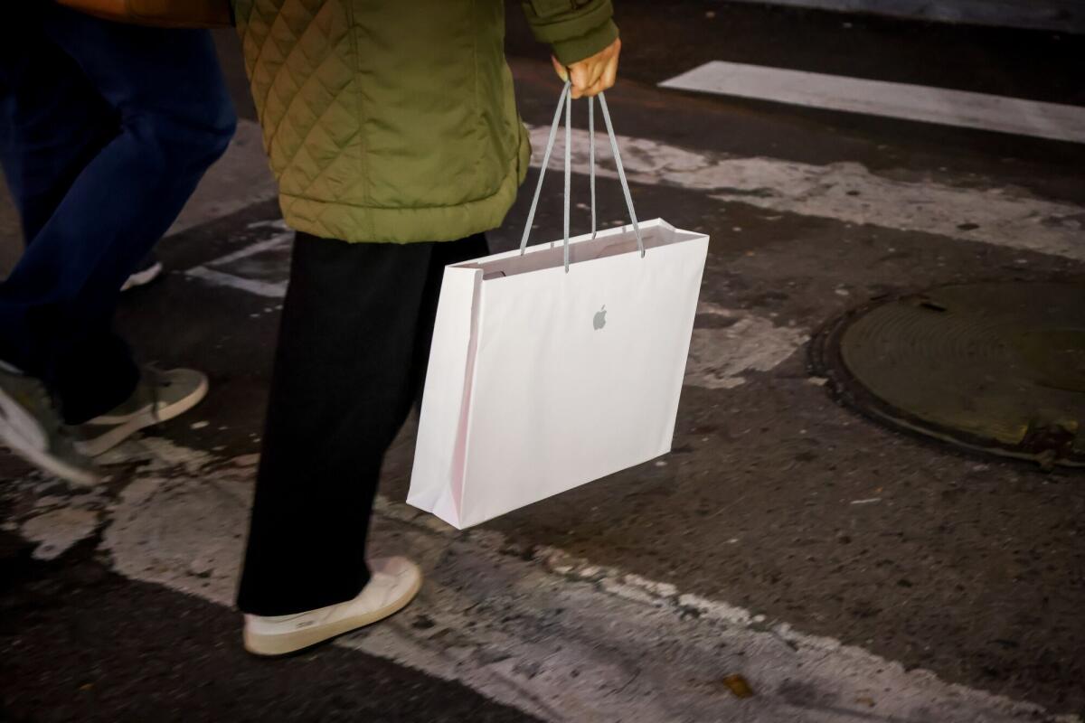 A shopper carries an Apple bag in New York.