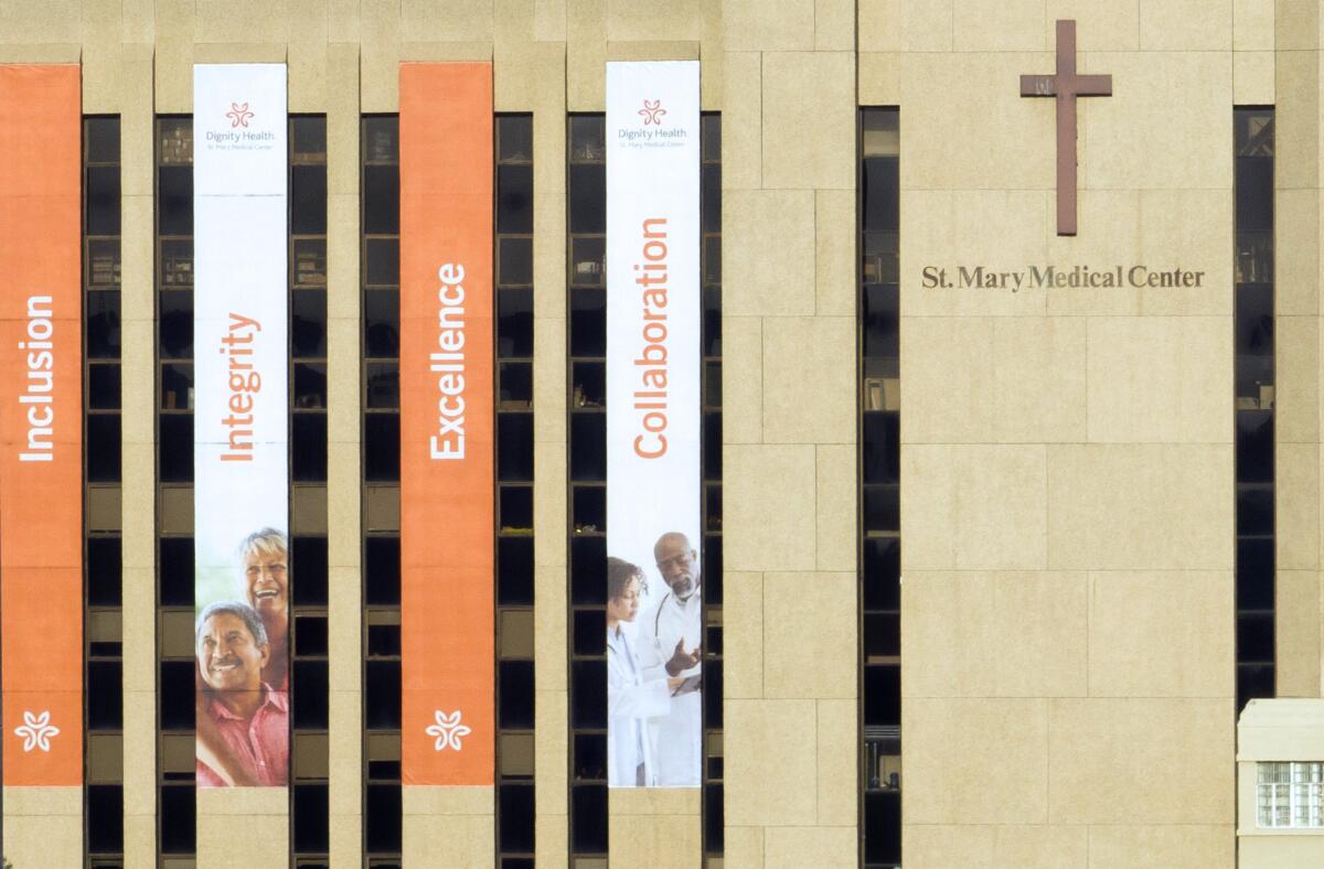 A multistory building draped with vertical banners reading "inclusion," "integrity," "excellence" and "collaboration." 