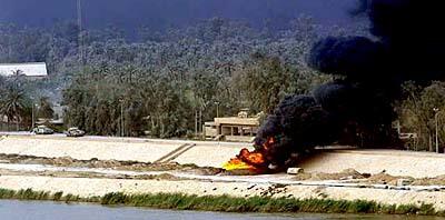 An oil fire burns along the riverbank in Baghdad.