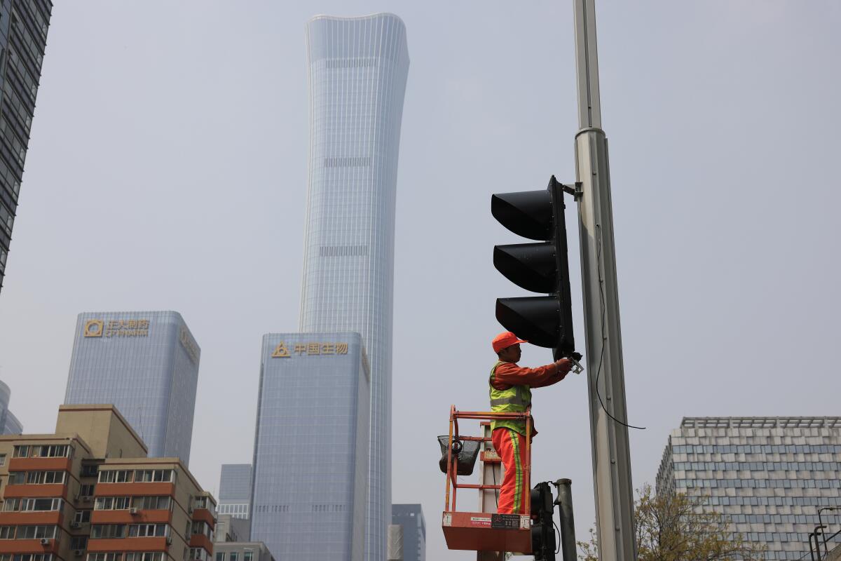 Worker installing traffic light