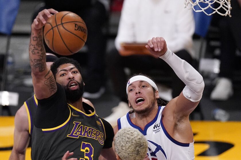 Los Angeles Lakers forward Anthony Davis, left, grabs a rebound away from Denver Nuggets forward Aaron Gordon during the first half of an NBA basketball game Monday, May 3, 2021, in Los Angeles. (AP Photo/Mark J. Terrill)