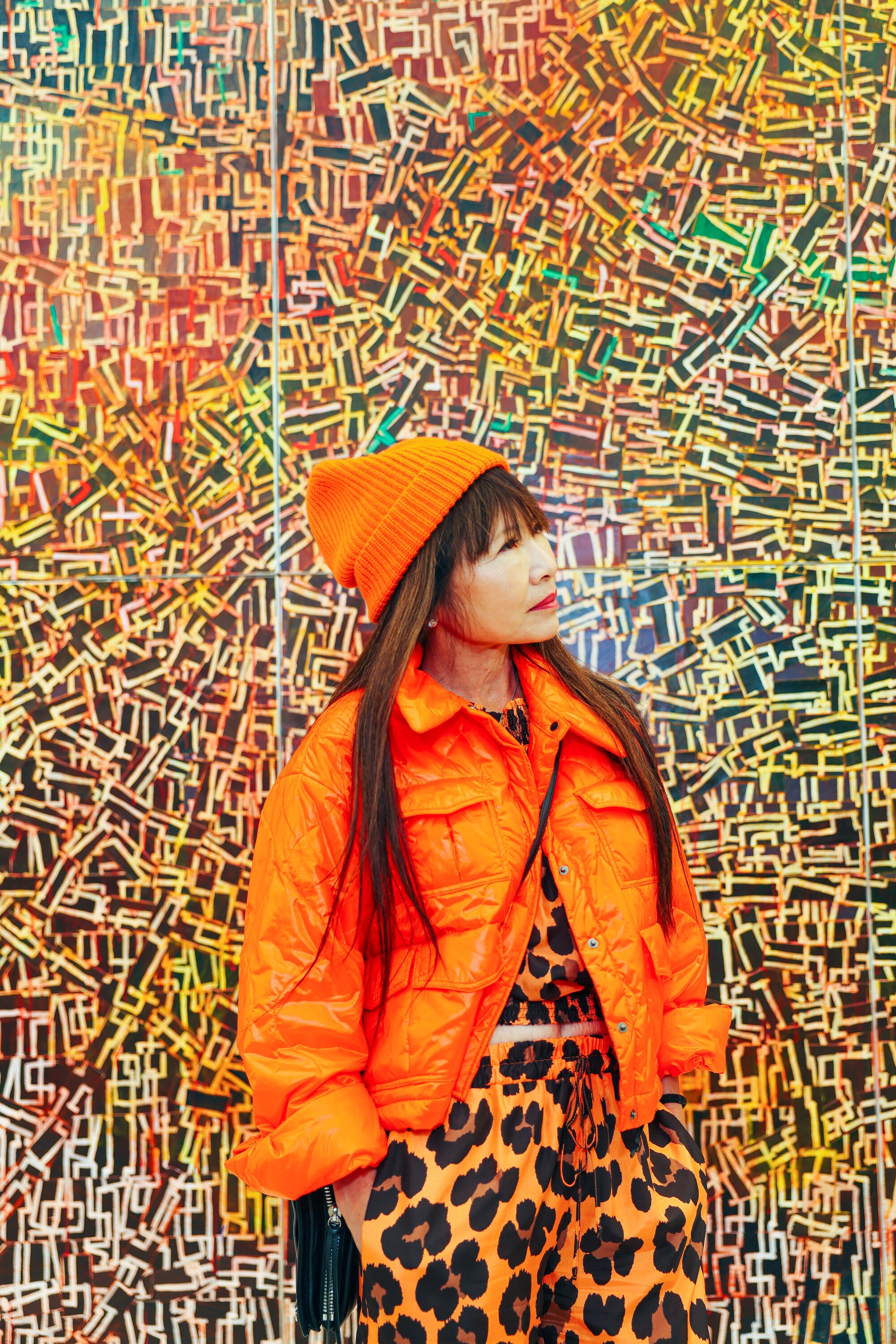 A person poses in front of a work of art.