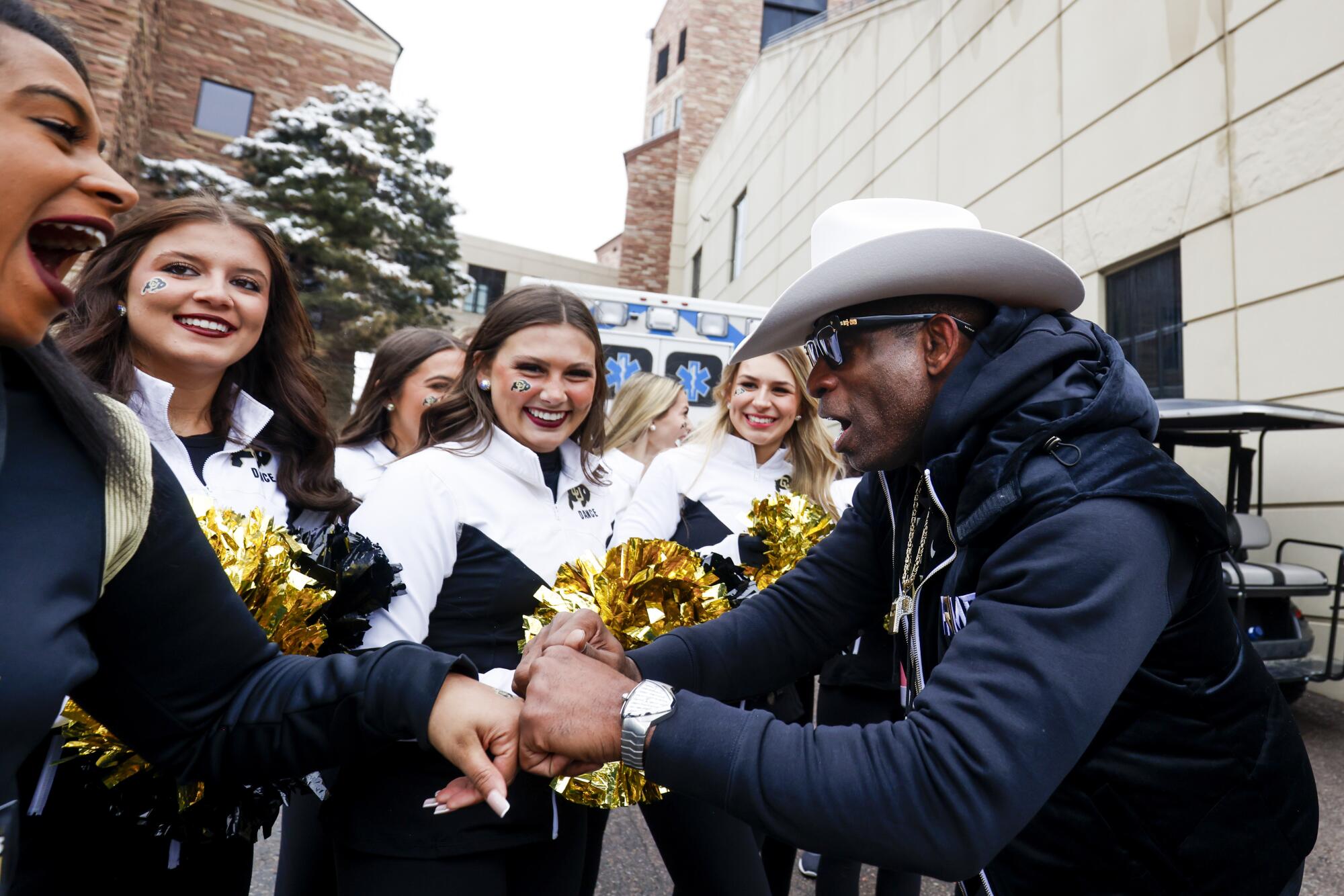 Colorado coach Deion Sanders gives fist bumps to cheerleaders before the Buffaloes' spring football game on April 22