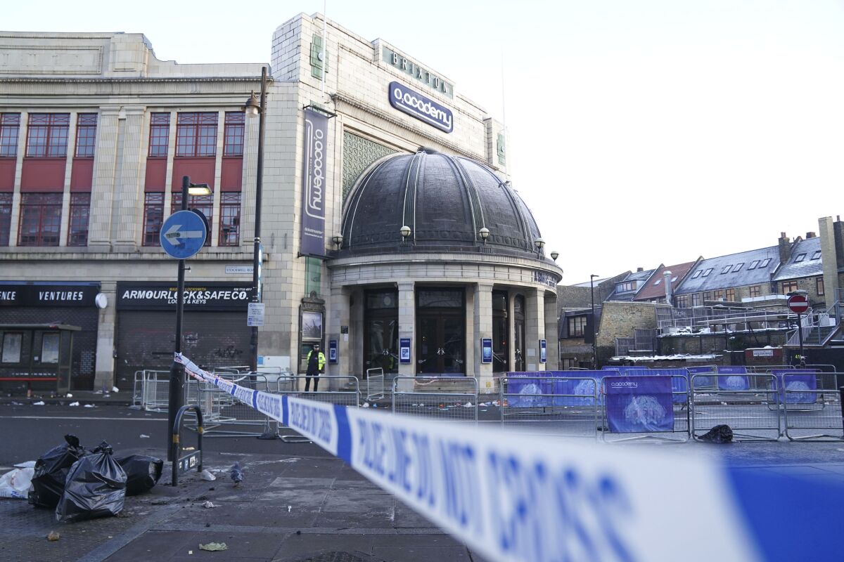The scene outside Brixton O2 Academy where police are investigating the circumstances which led to four people sustaining critical injuries in an apparent crush as a large crowd tried to force their way into the south London concert venue, Friday Dec. 16, 2022. Four people were hospitalized in critical condition on Friday after a suspected crush at a London concert venue, where Nigerian singer Asake was performing. (Kirsty O'Connor/PA via AP)