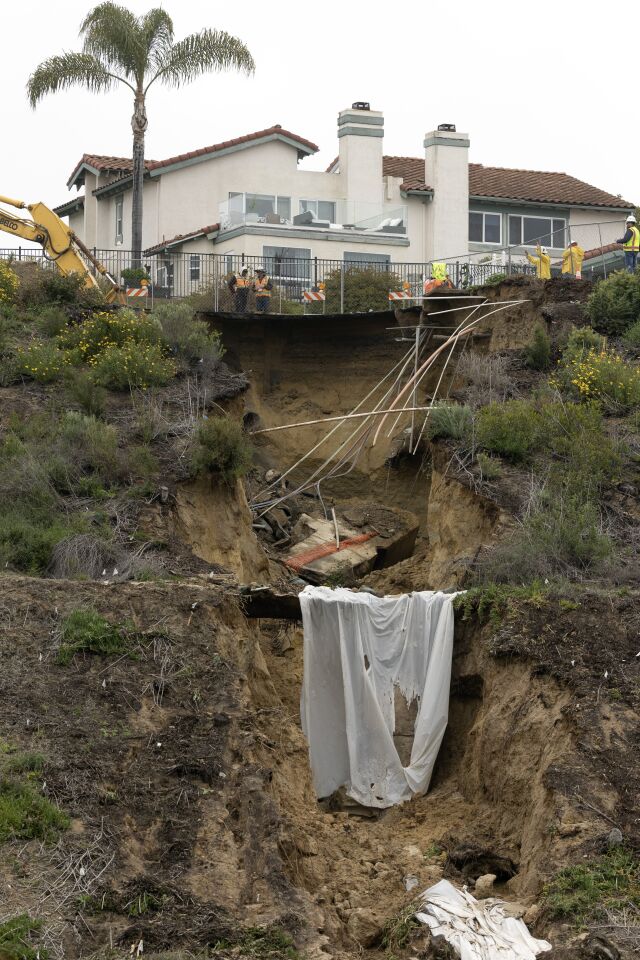 Runoff that caused a large sinkhole from recent rains flowed down a ravine at the south end of Lake Drive in Cardiff as work goes on to repair it on Saturday, March 11, 2023.