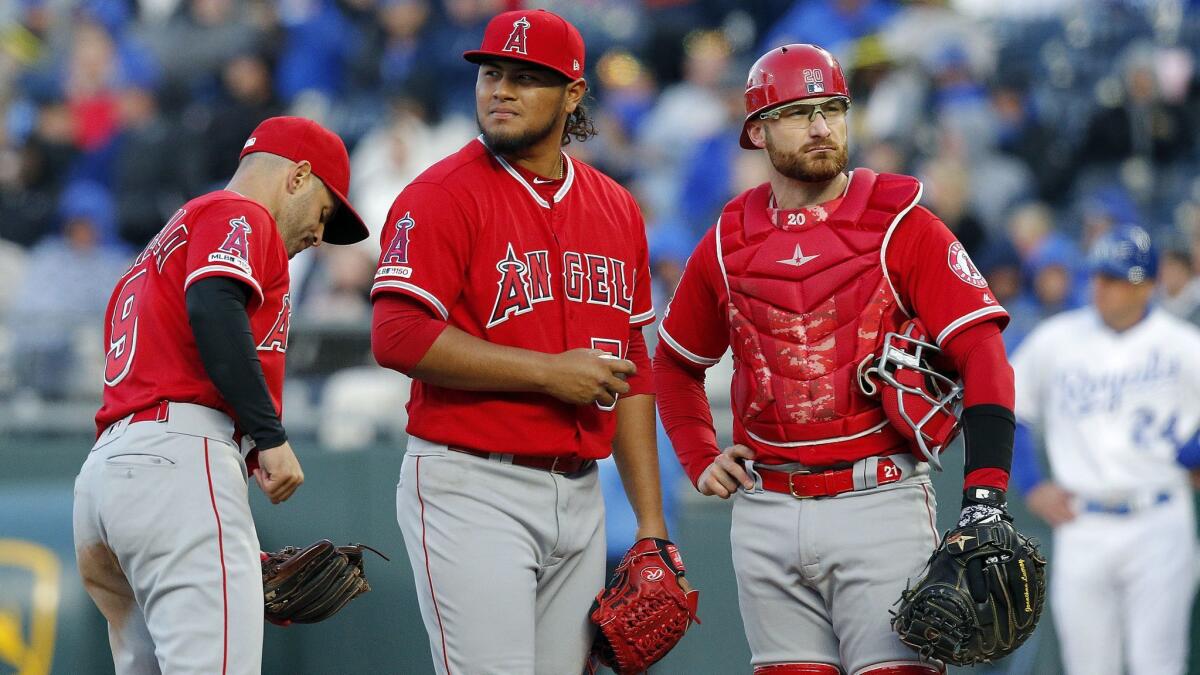 Angels pitcher Jaime Barria (51) waits to be relieved in the third inning as he stands with Tommy La Stella (9) and Jonathan Lucroy (20) against the Kansas City Royals on Saturday.