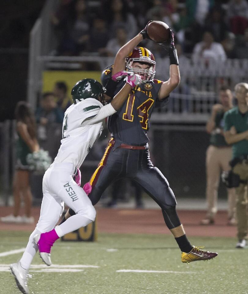 Estancia High's Trevor Brown (14) leaps for a catch against Costa Mesa.